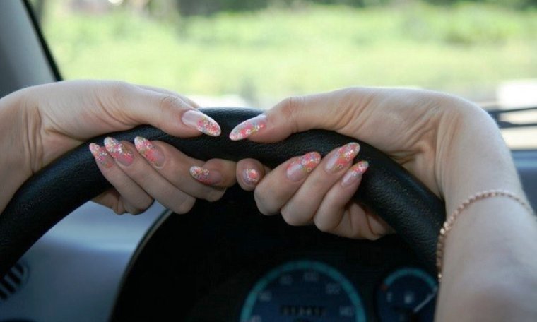 Рука девушки за рулем
