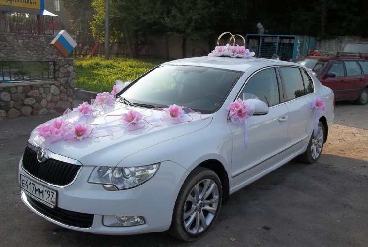 Машина на свадьбу украшенная кольцами из лент