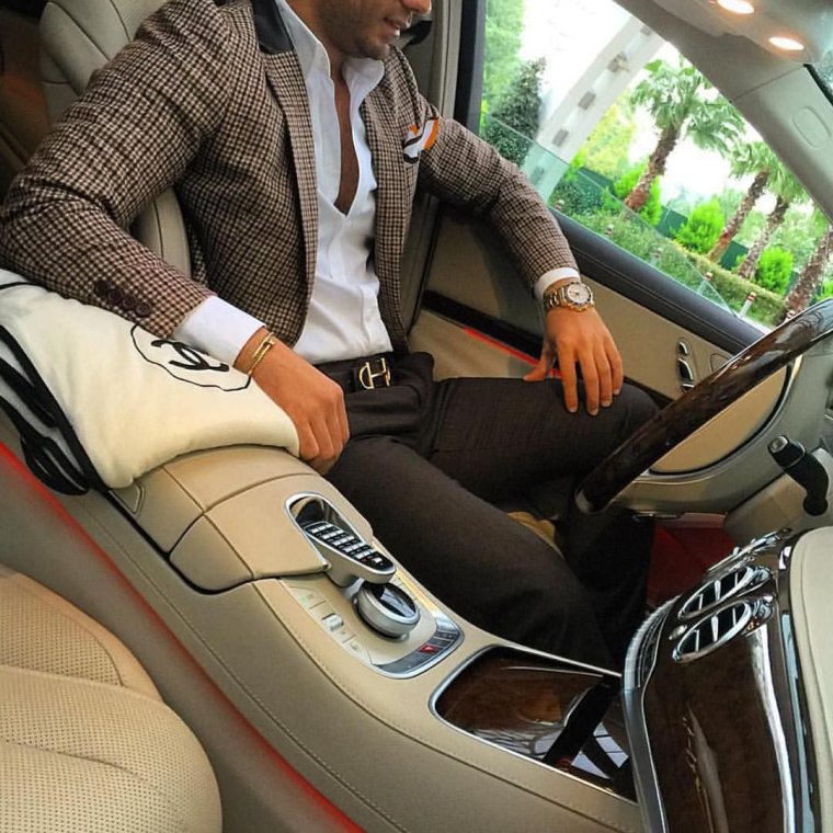 Красивый молодой человек в костюме около машины