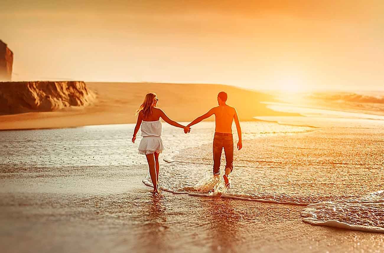 Навстречу морю. Влюбленные на берегу моря. Пара на пляже. Прогулки по берегу моря влюбленных. Мужчина и женщина идут по берегу моря.