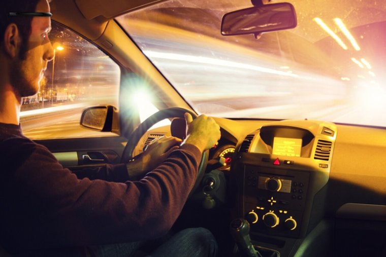 Человек за рулем автомобиля ночью