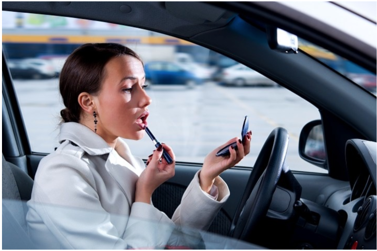 Женщина красится за рулем