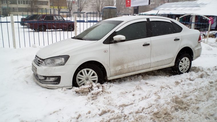 Белый седан Volkswagen Polo зима