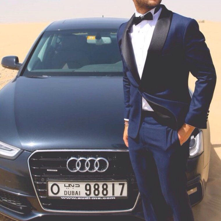 Мужчина рядом с машиной в костюме