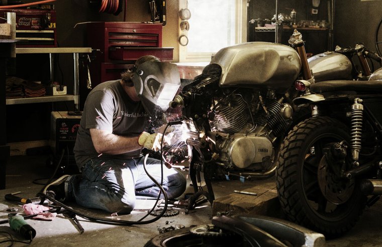 Мужик ремонтирует мотоцикл