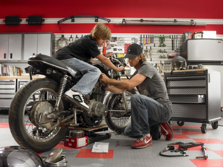 Чинит мотоцикл