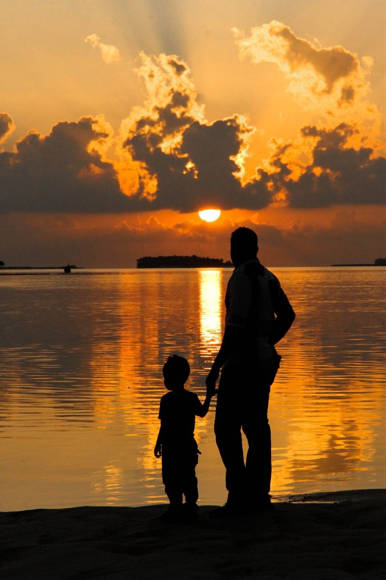 Папа с ребенком на фоне заката