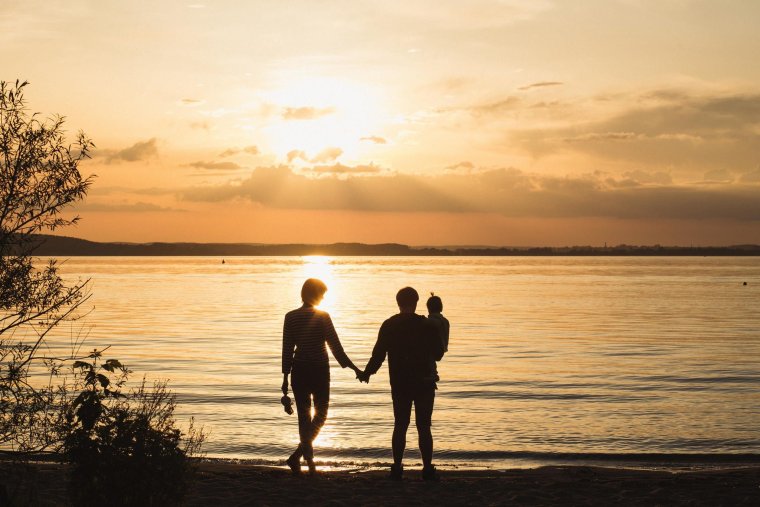 Семейная пара на закате с ребенком