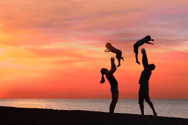 Счастливая спортивная семья на закате