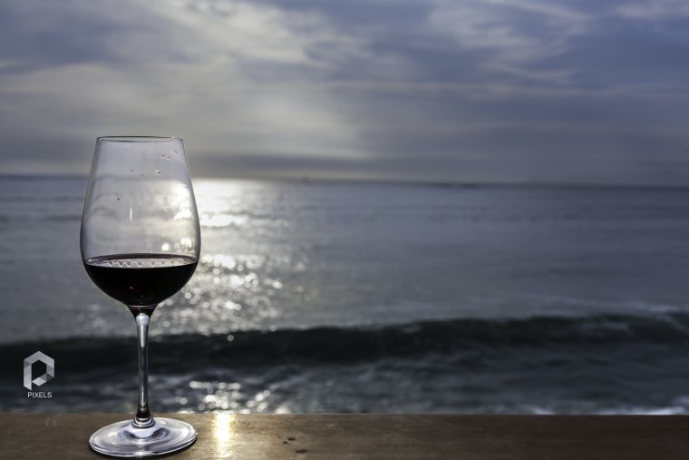 Красное вино на пляже и закат