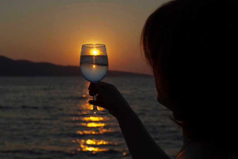 Девушка с бокалом на море