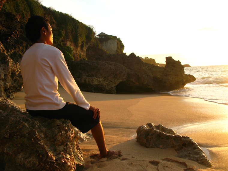 Парень сидит на берегу моря