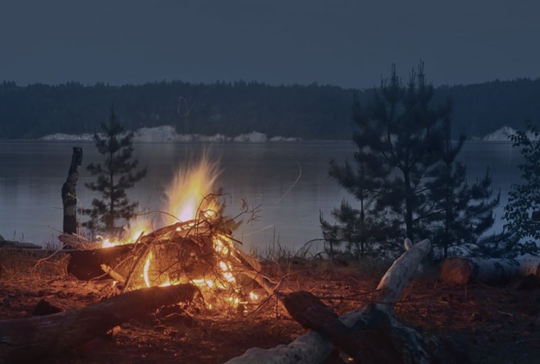 Костер на берегу реки ночью