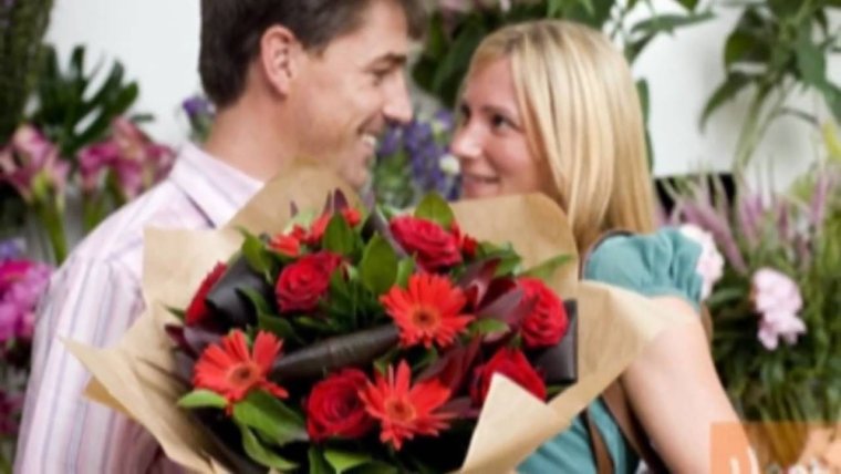 Мужчина дарит цветы женщине