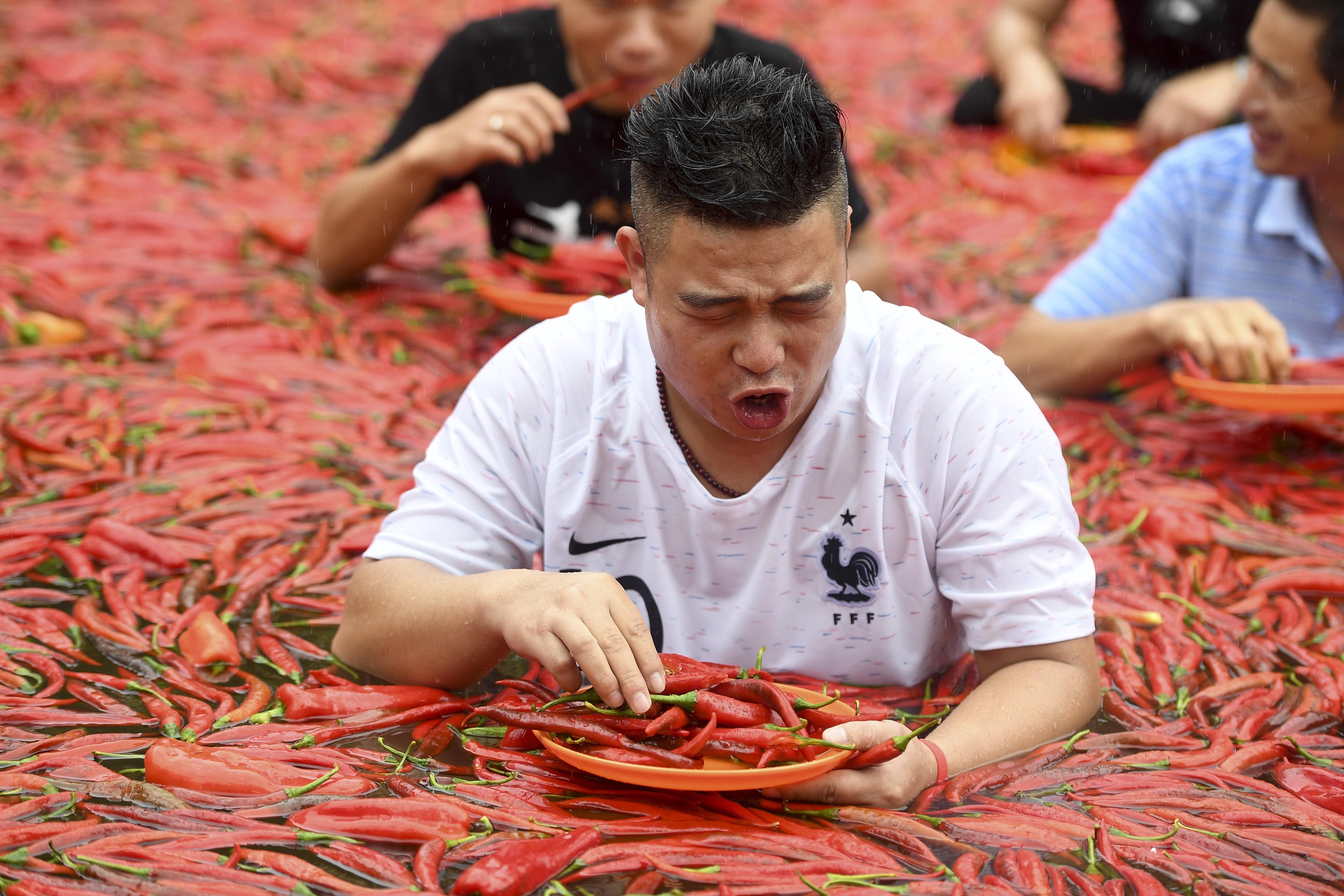 Китай удивлен. Соревнования по поеданию перца. Соревнования по поеданию острого перца. Китайские люди.