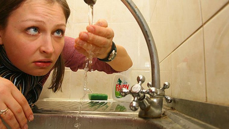 Кот умывается в умывальнике