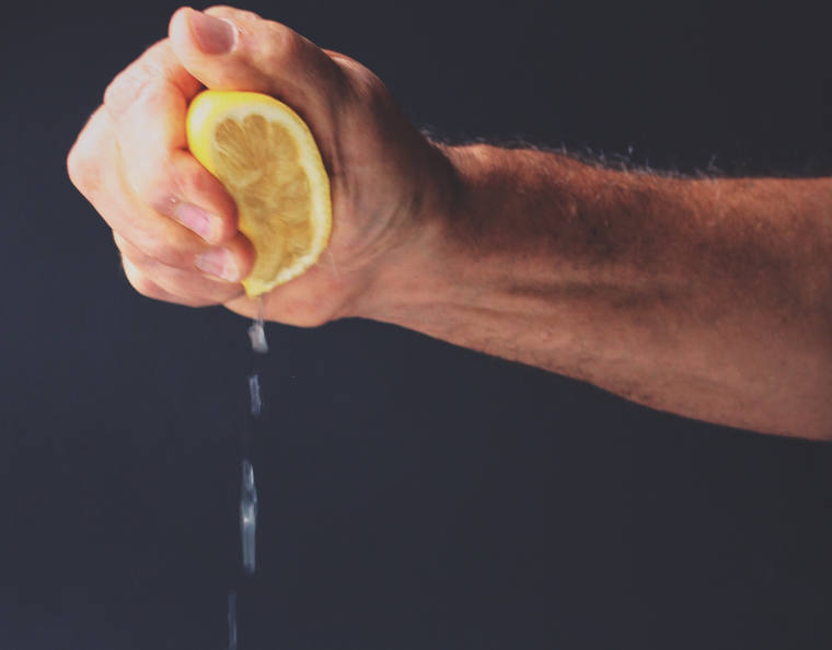 Рука выжимает лимон