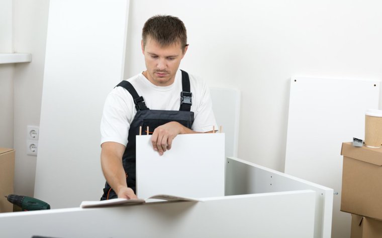 Мужчина собирает кровать