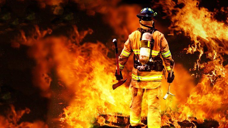 Пожарник на фоне пожара