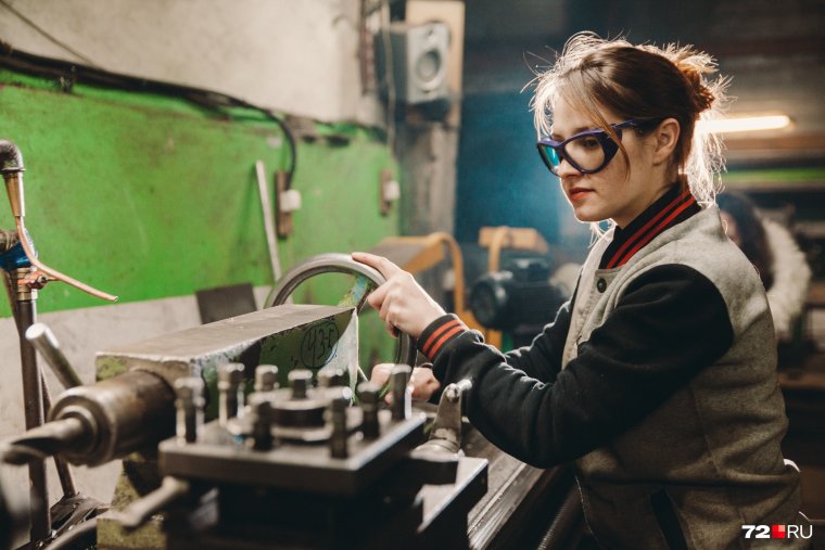 Женщина за станком на заводе