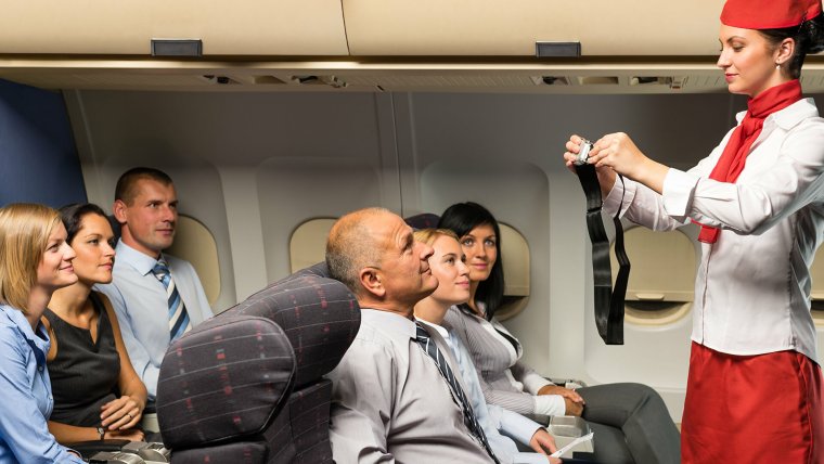 Салон самолета с пассажирами с стюардессой