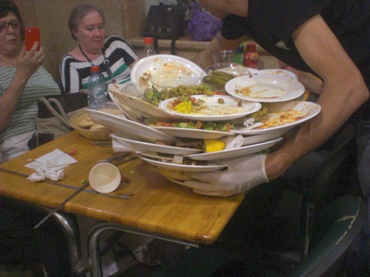 Официант убирает посуду со стола