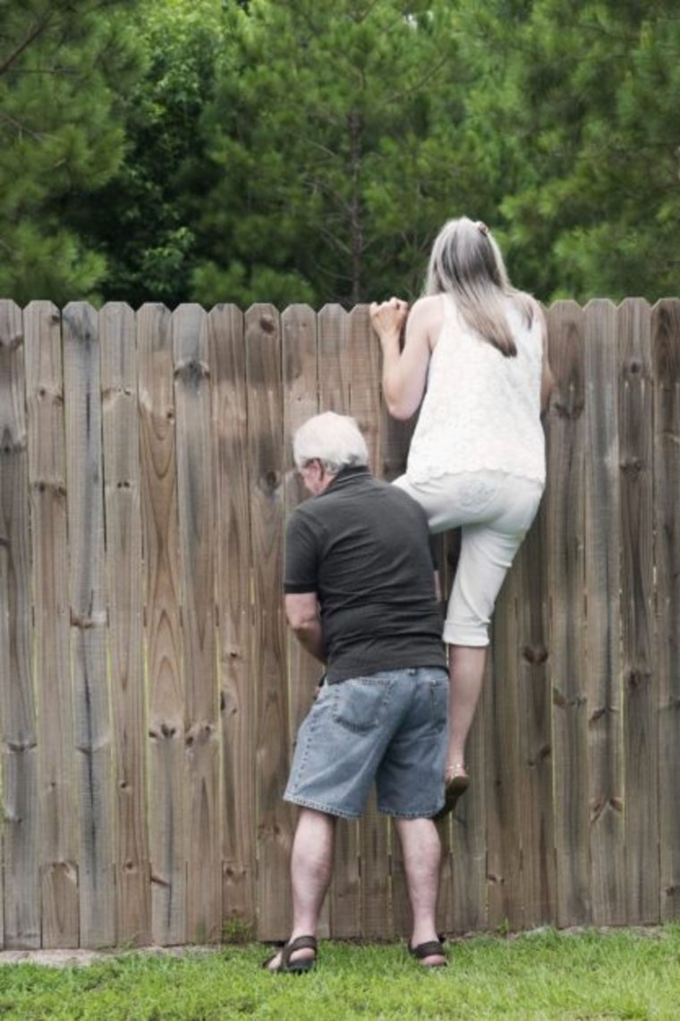 Человек перелезает через забор