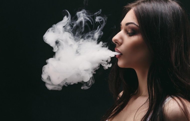 Выдыхает дым