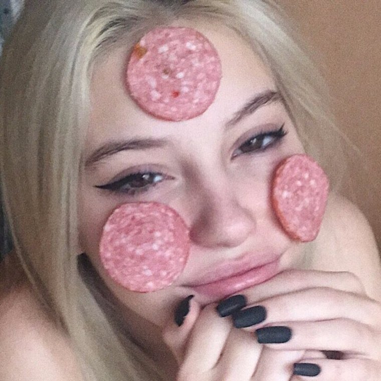 Девушка ест колбасу