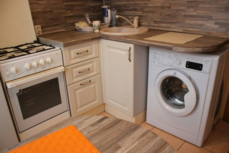 Стиральная машина на маленькой кухне под столешницей