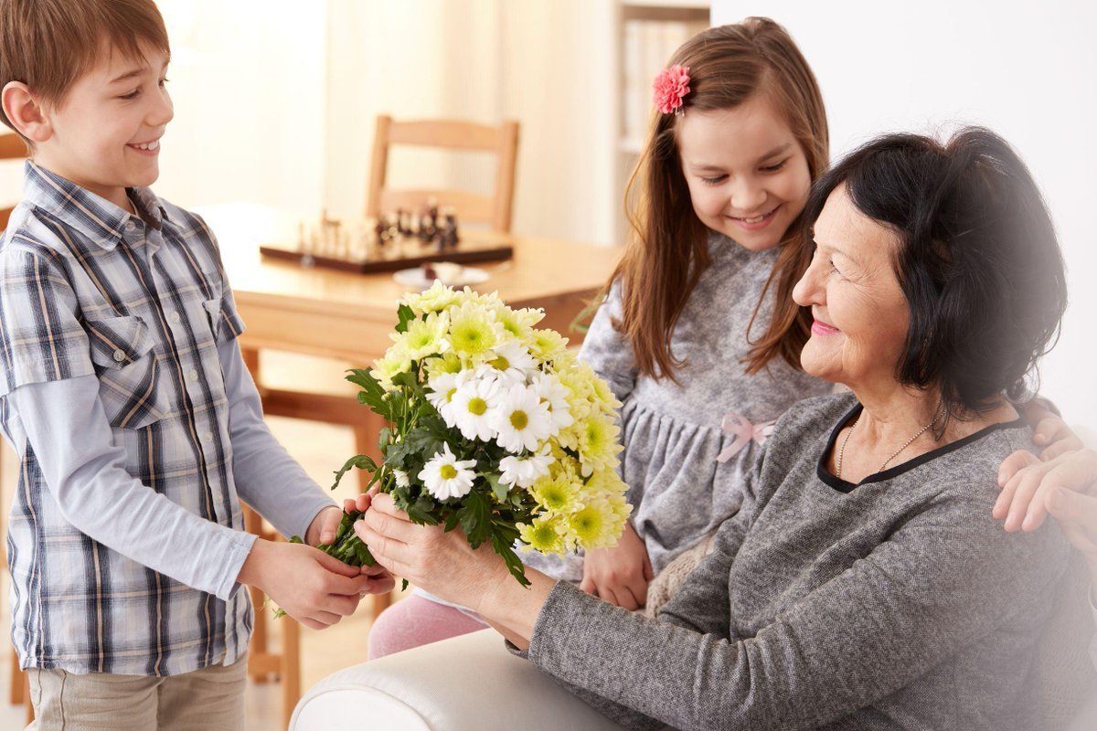 Ребенок дарит цветы маме. Внучка дарит цветы бабушке. Внук дарит бабушке цветы. Ребенок дарит матери цветок.