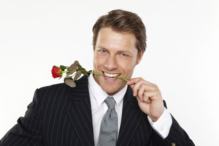 Мужчина с цветком в зубах