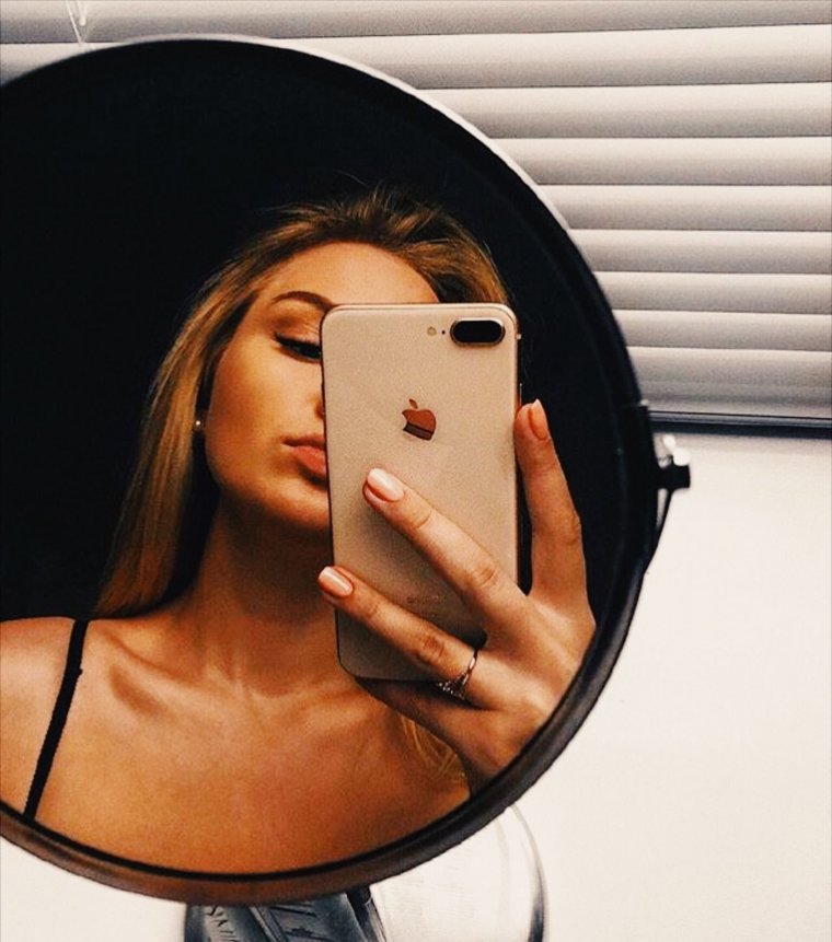 Девушка с айфоном в зеркале