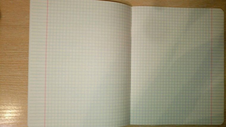 Тетрадь в клетку на столе