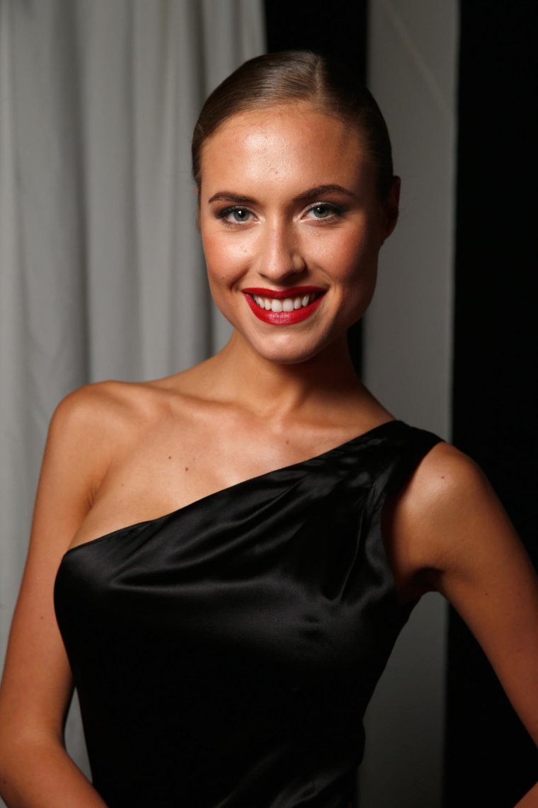 Спортсменка раздевается в лосинах и черном лифчике