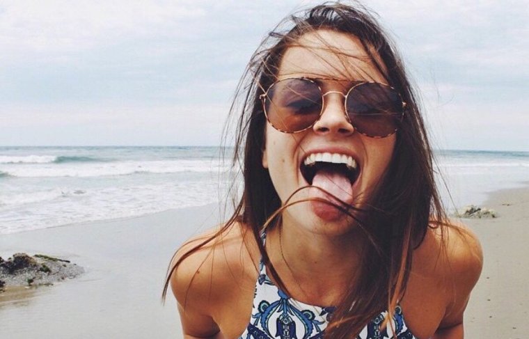 Девушка на пляже улыбается